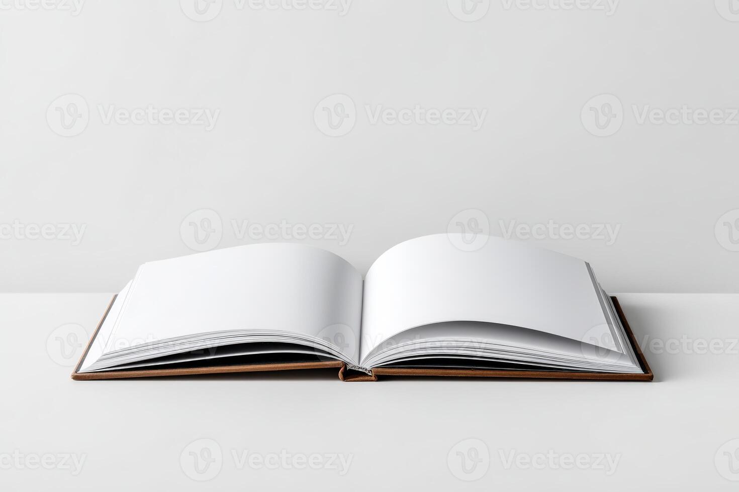 Open blank book displaying empty pages on a minimalist surface in a bright setting photo