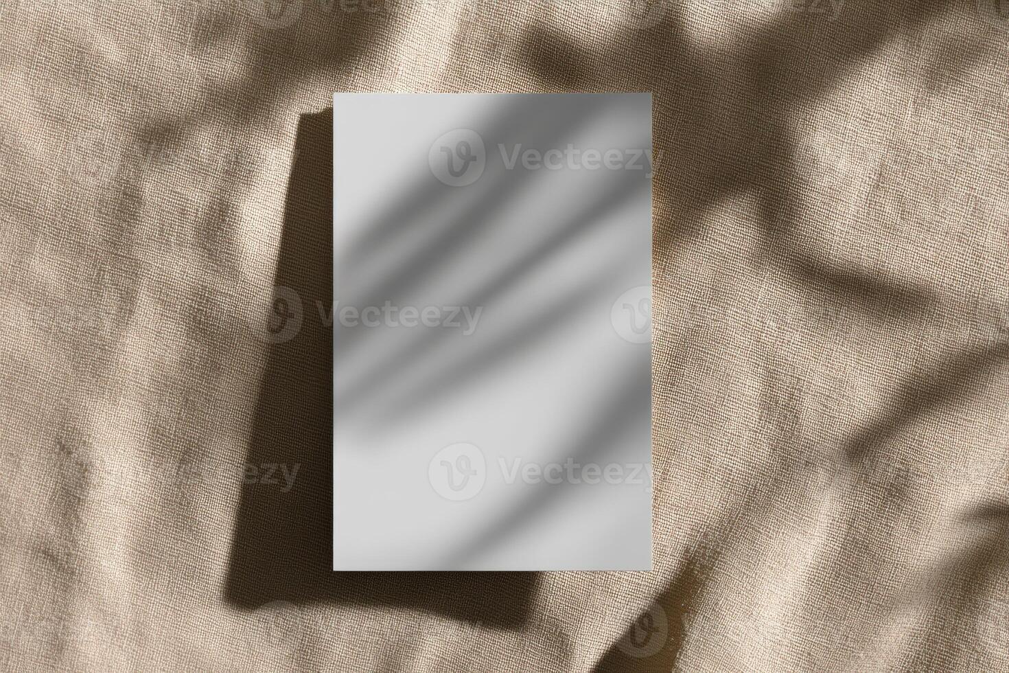 Minimalist composition featuring blank card on soft textile background with shadow play photo