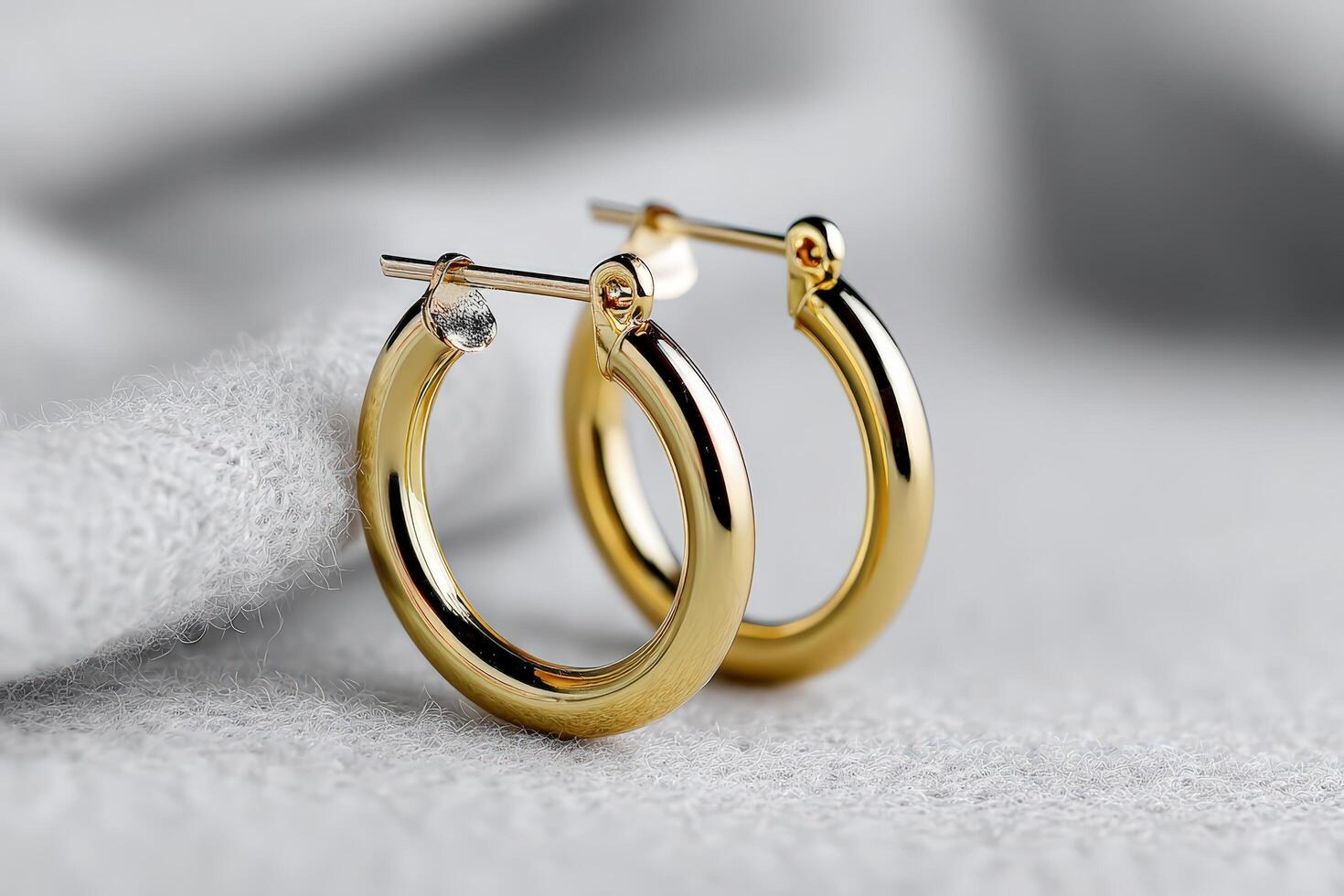 Gold hoop earrings on soft fabric showcase their elegant shine and style photo