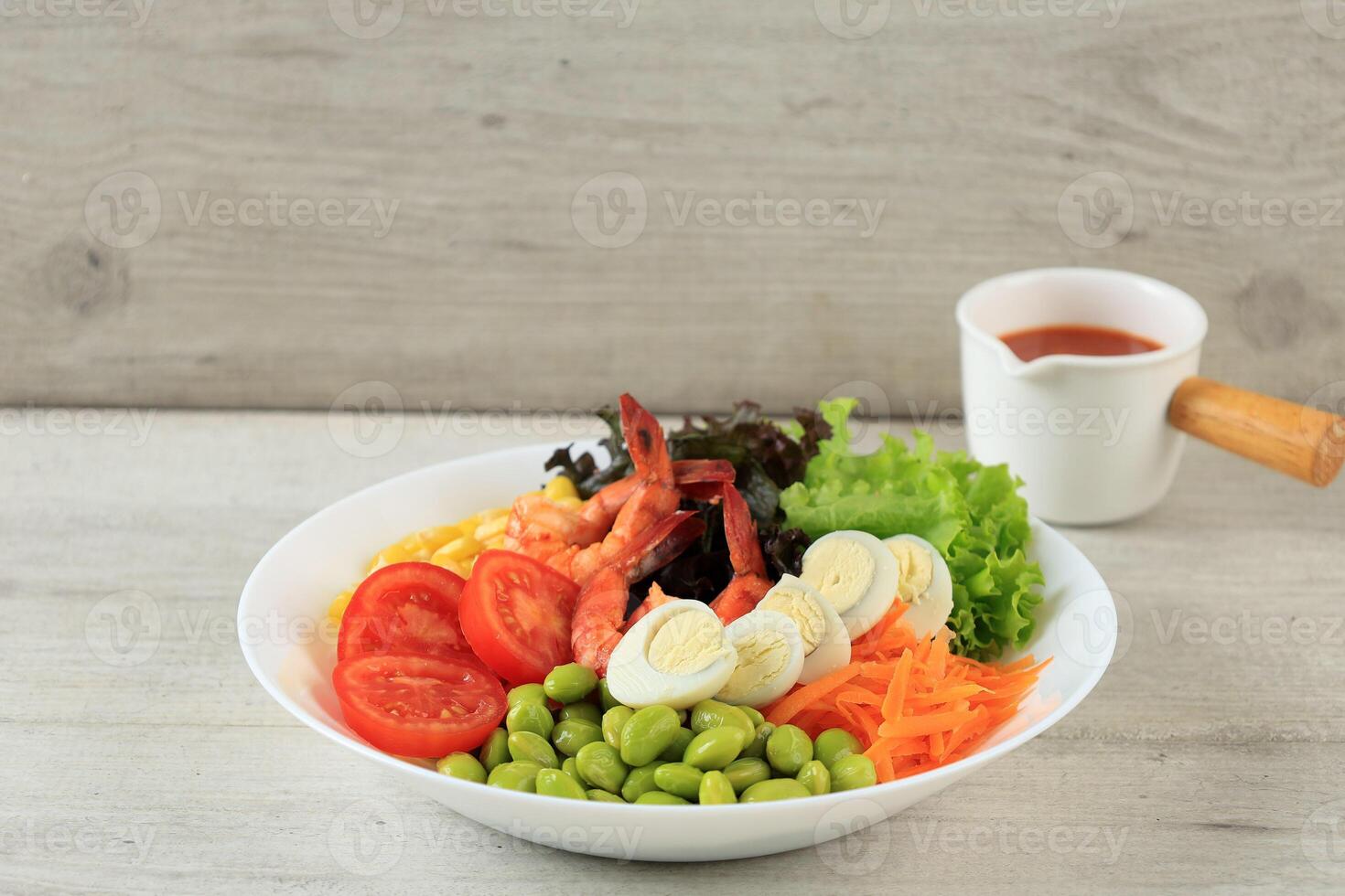 Fresh Shrimp Salad with Quail Eggs, Tomato, Lettuce, Edamame, Corn, and Carrot. With Red Spicy and Sweet Dressing photo