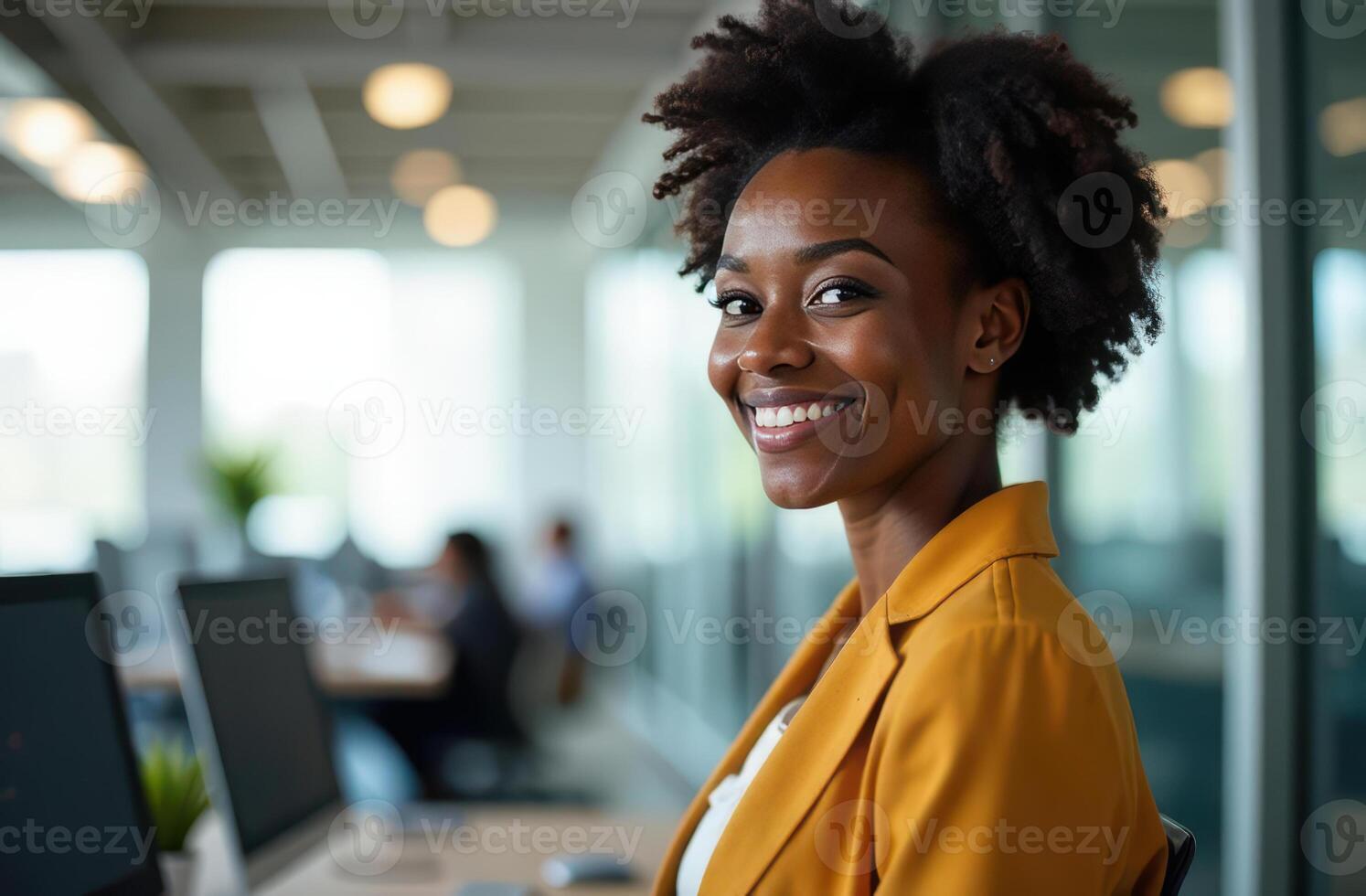 Confident professional woman smiling at modern office desk in bright open workspace. international workers day photo