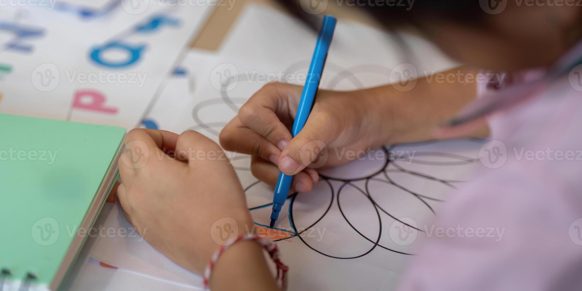 Focus and Creativity. A child drawing intricate patterns on paper. photo