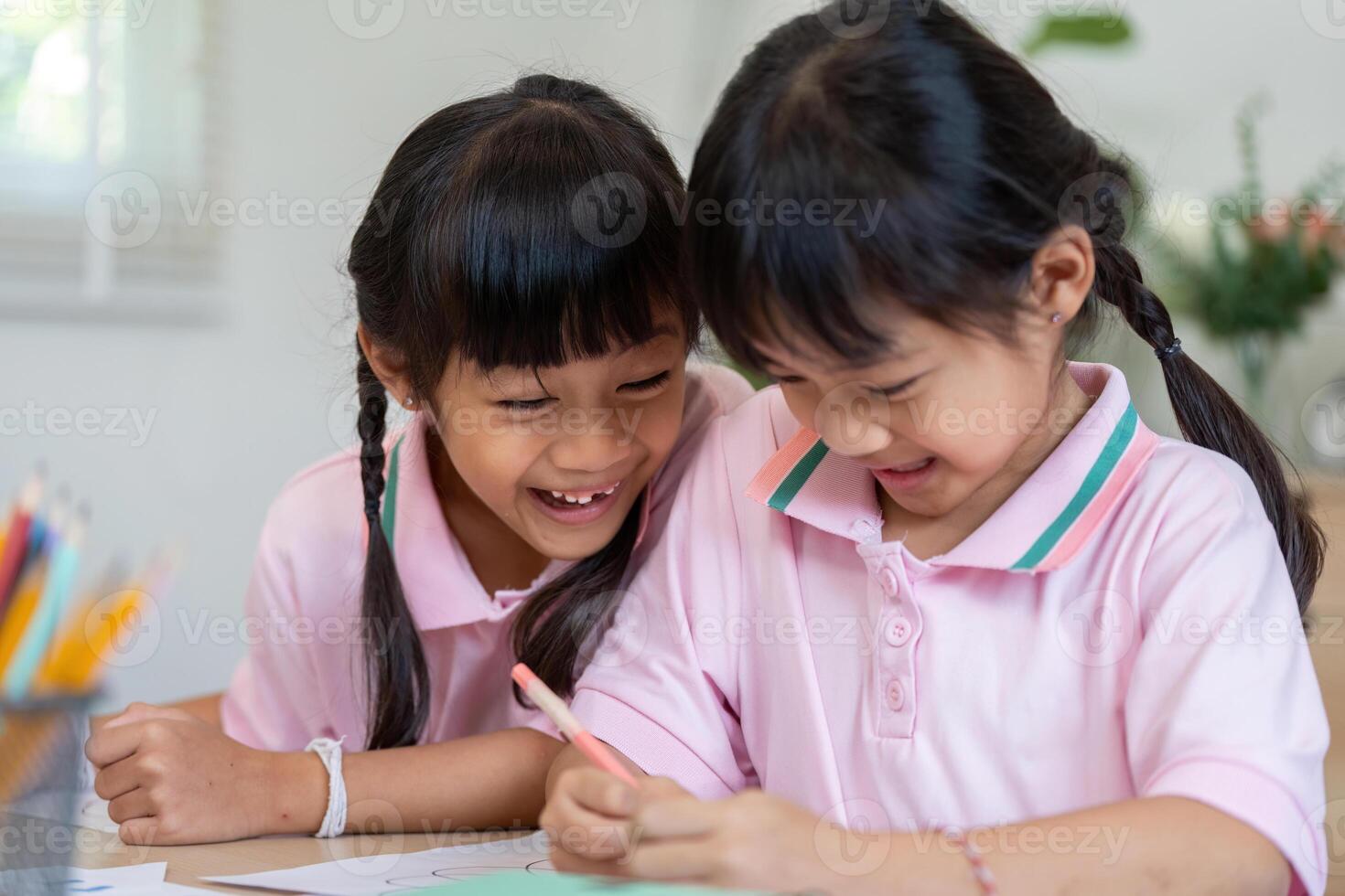 Joy and Learning. Two girls enjoying a fun moment while coloring together. photo
