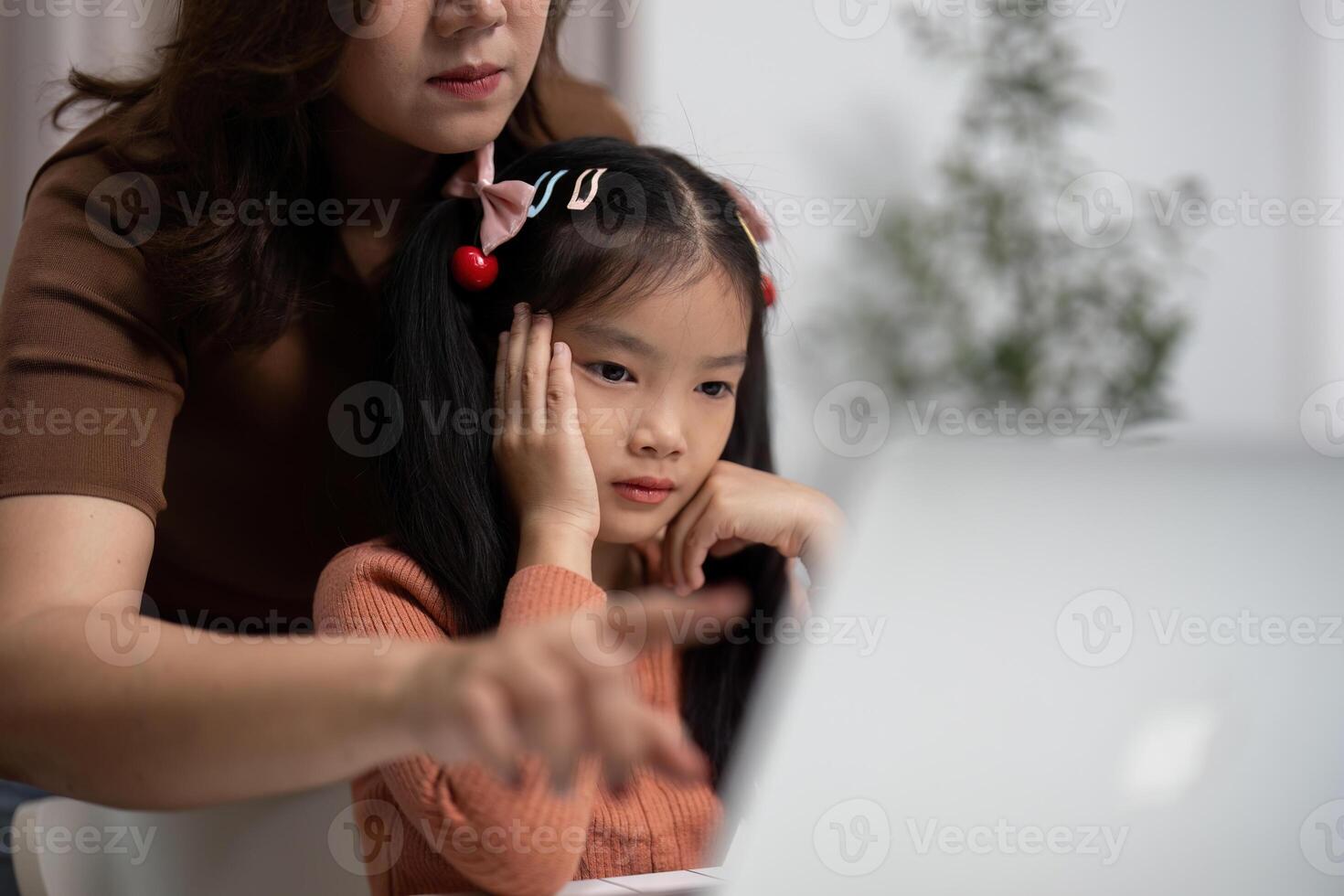 Back to School and Focused Learning. A mother guides her daughter through online tasks, ensuring she stays engaged. photo