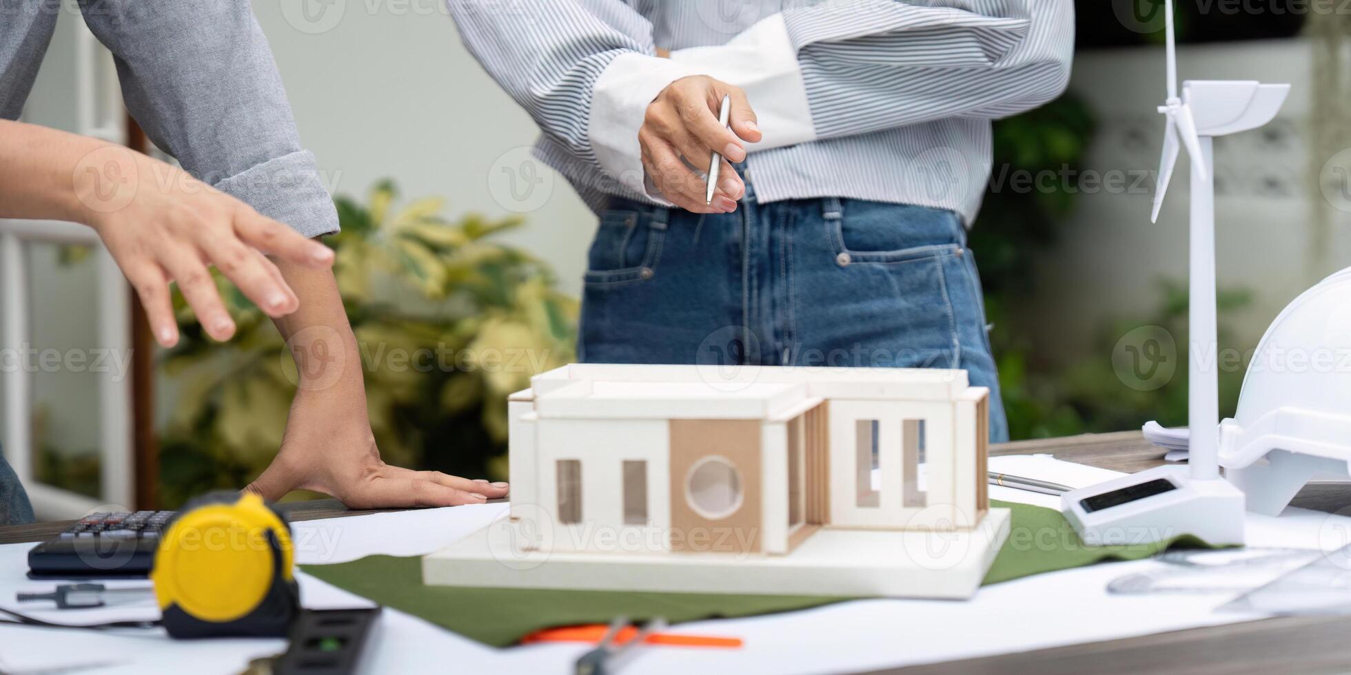 Sustainability and Architectural Model. Professionals discussing a sustainable building model with renewable energy features. photo
