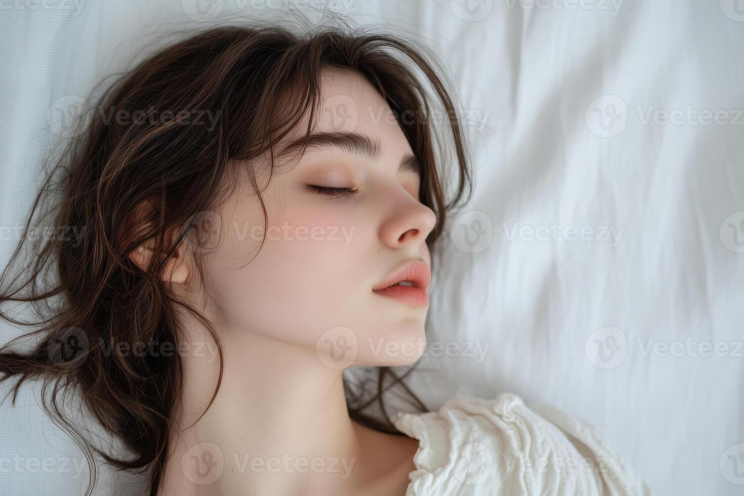 Portrait of a Young Woman with Closed Eyes, Lying on a White Bed photo
