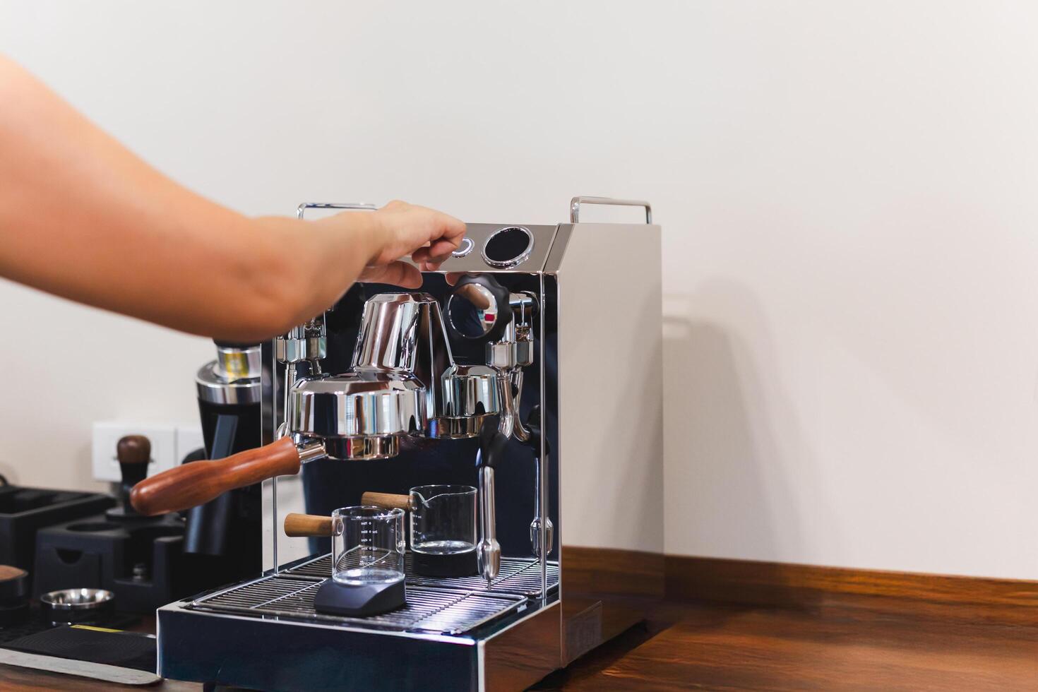 Barista hand presses a button while making fresh coffee. photo