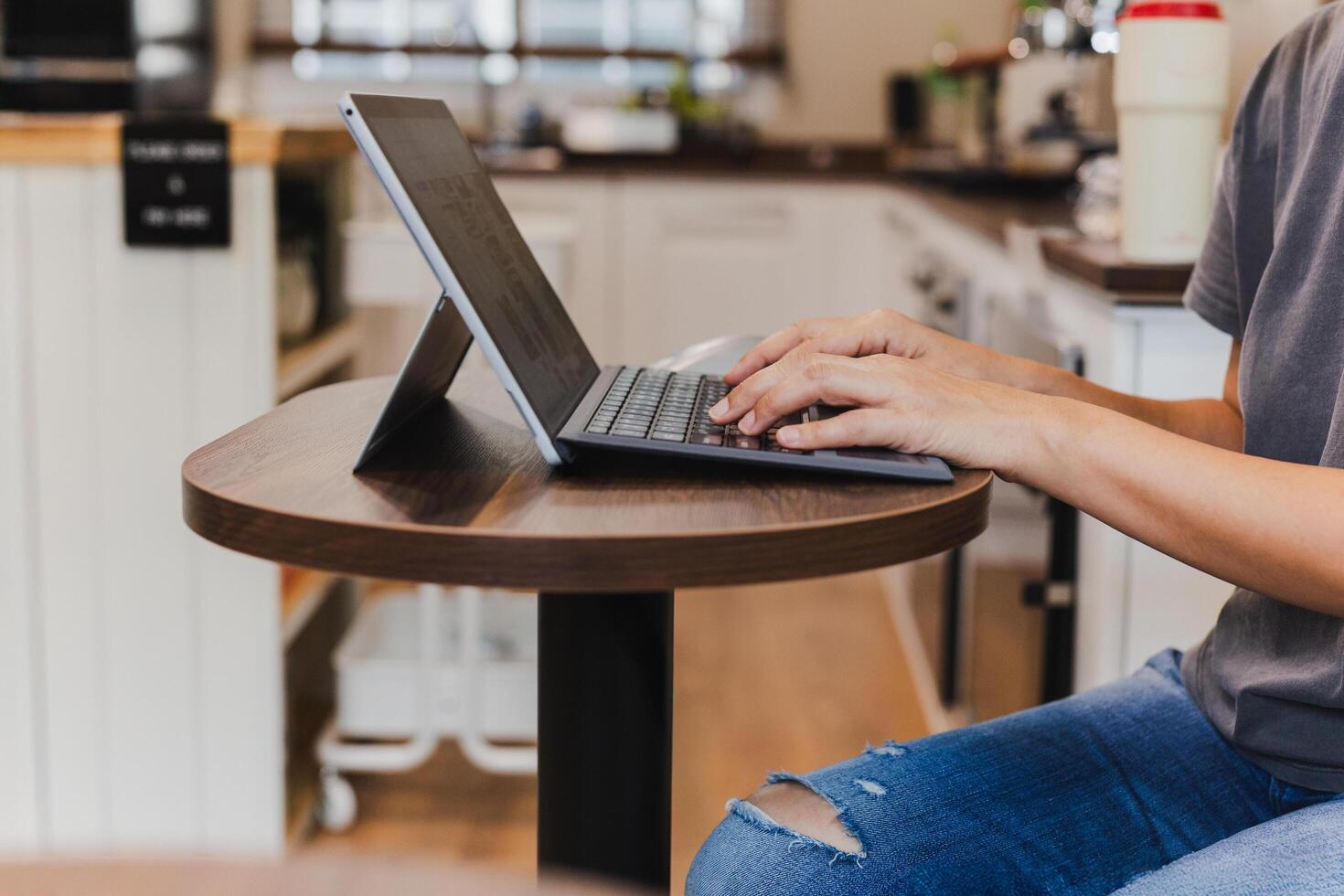 Womans hands typing on laptop keyboard in cafe. photo