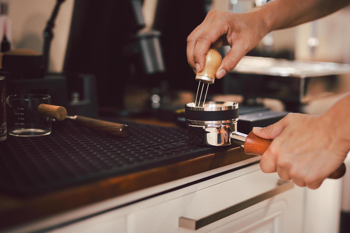 Barista leveling ground coffee in the portafilter photo