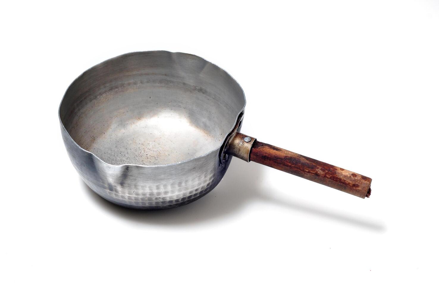 An empty kadhai with its wooden handle photo