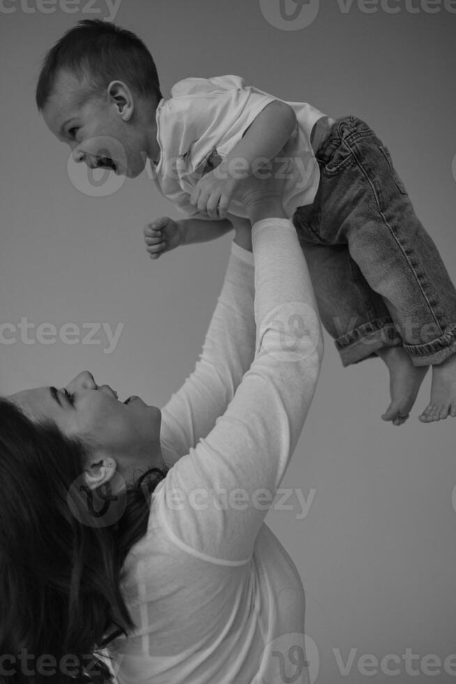 Young mother with her two year old son, dressed in the same style, relaxing and playing together. photo