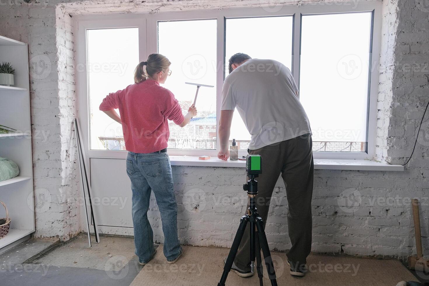 caucasian couple toning windows glass at home using toning film photo