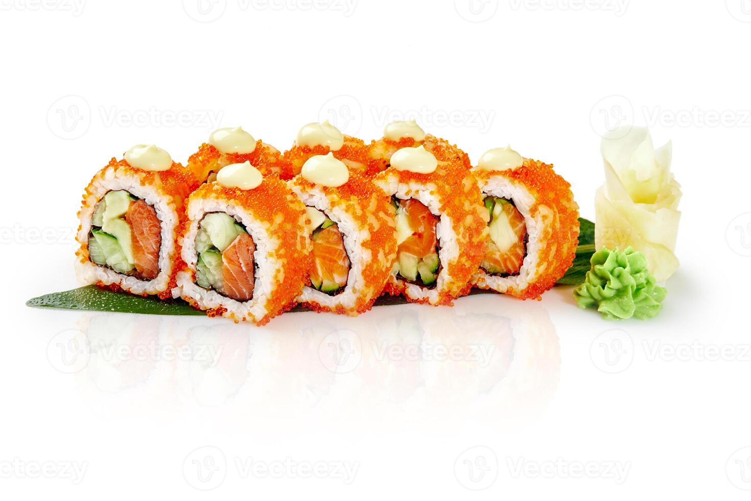 California uramaki sushi rolls covered with red tobiko caviar resting on a bamboo leaf photo