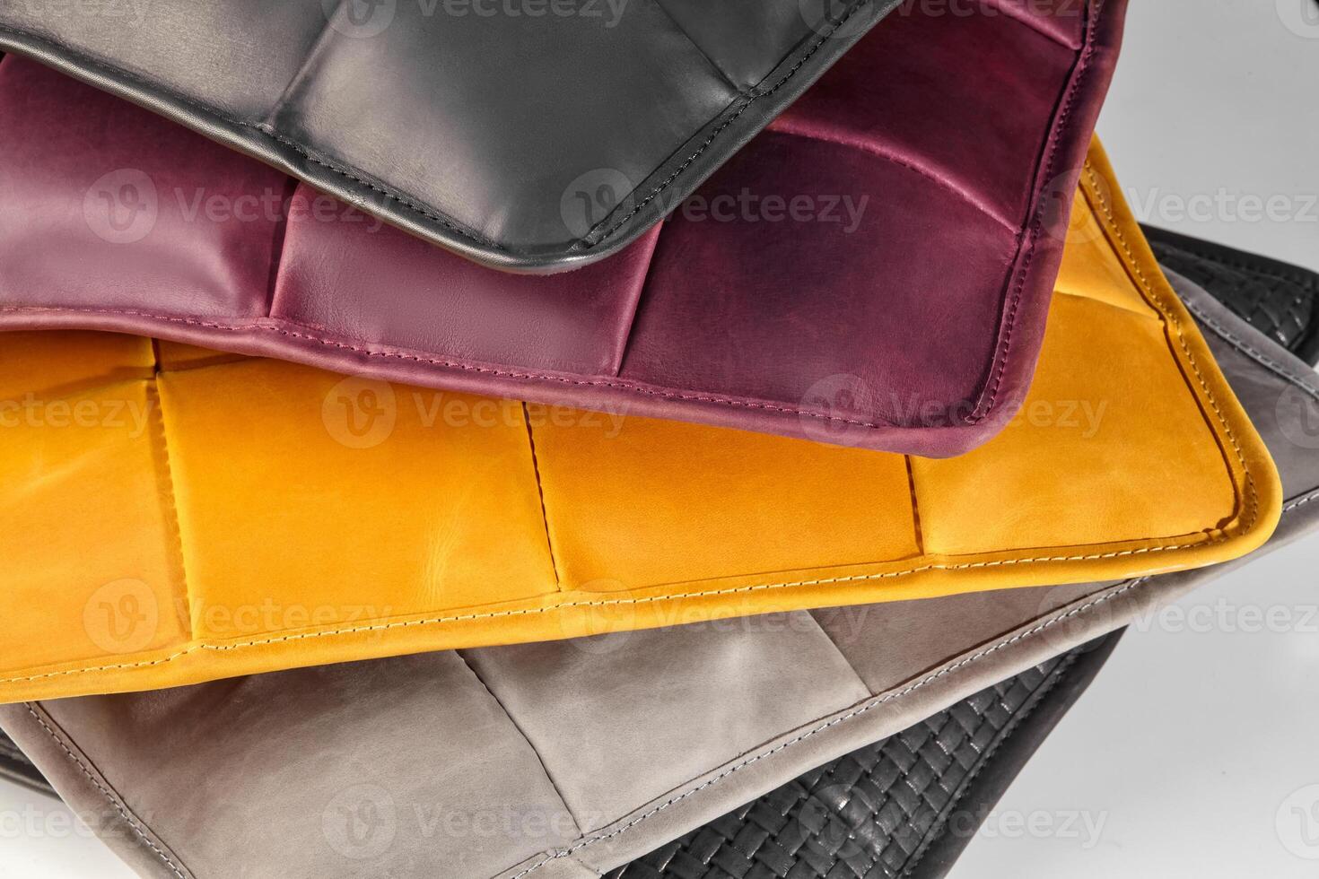 Stack of colorful leather placemats showing stitching detail photo