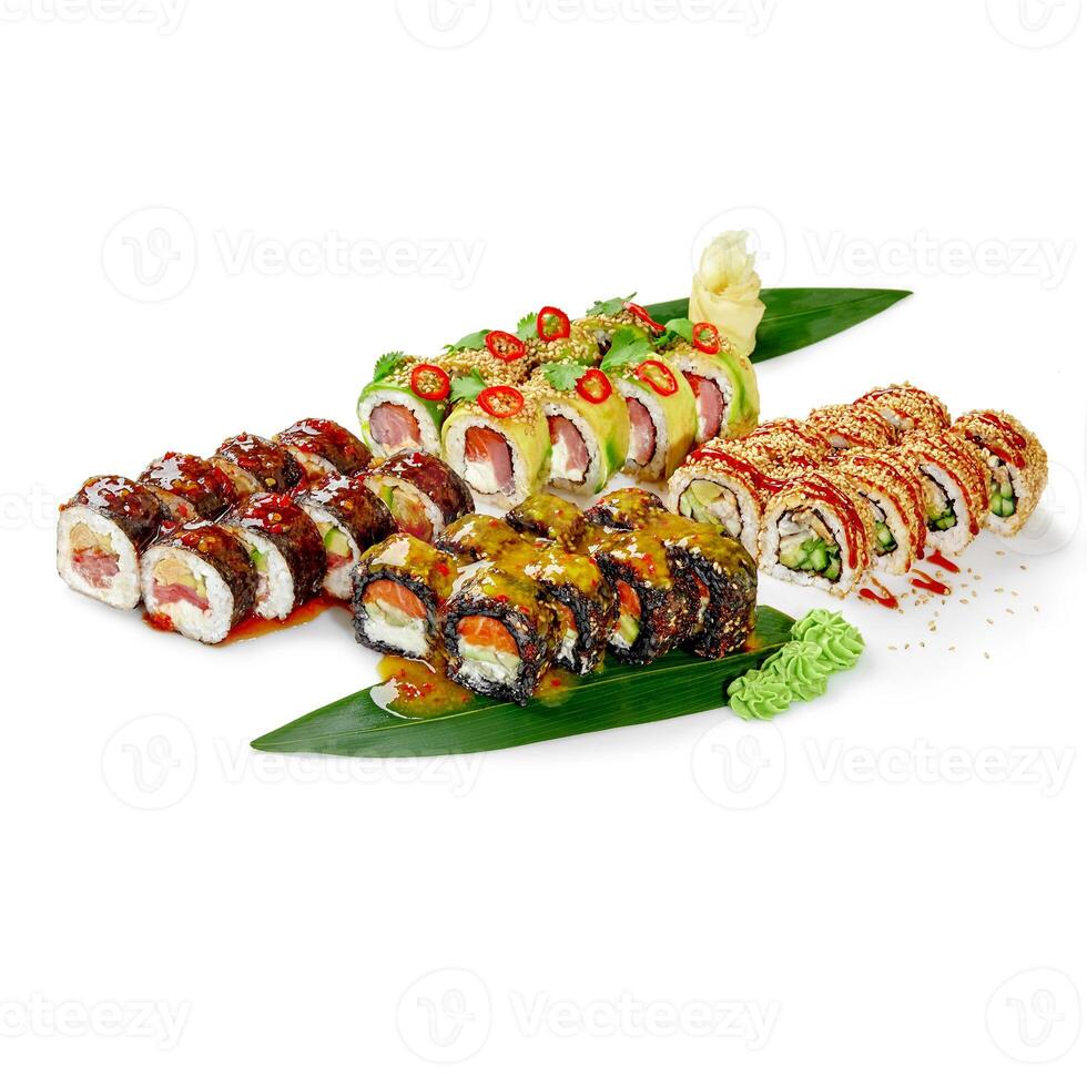 Variety of sushi rolls displayed on banana leaves with sesame seeds and spices photo