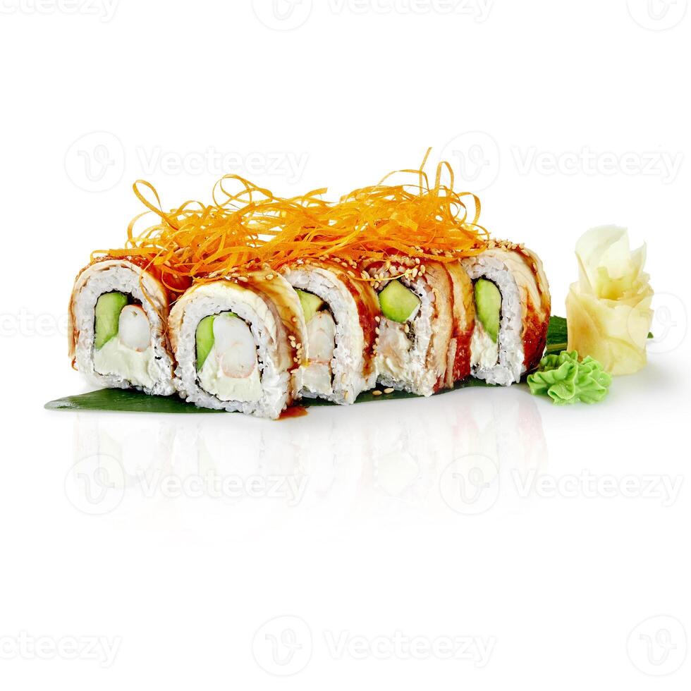 Dragon roll sushi with eel, shrimp, avocado, cream cheese, and sesame seeds displayed on banana leaf photo