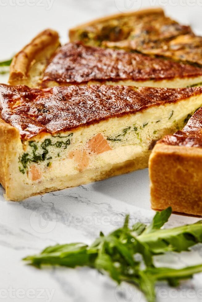 Delicious homemade salmon and spinach quiche resting on a marble surface photo
