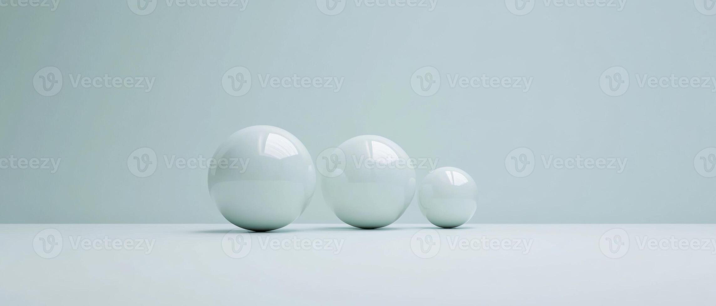 Three glossy spheres of varying sizes on a light blue background, representing growth, progression, and minimalist design photo