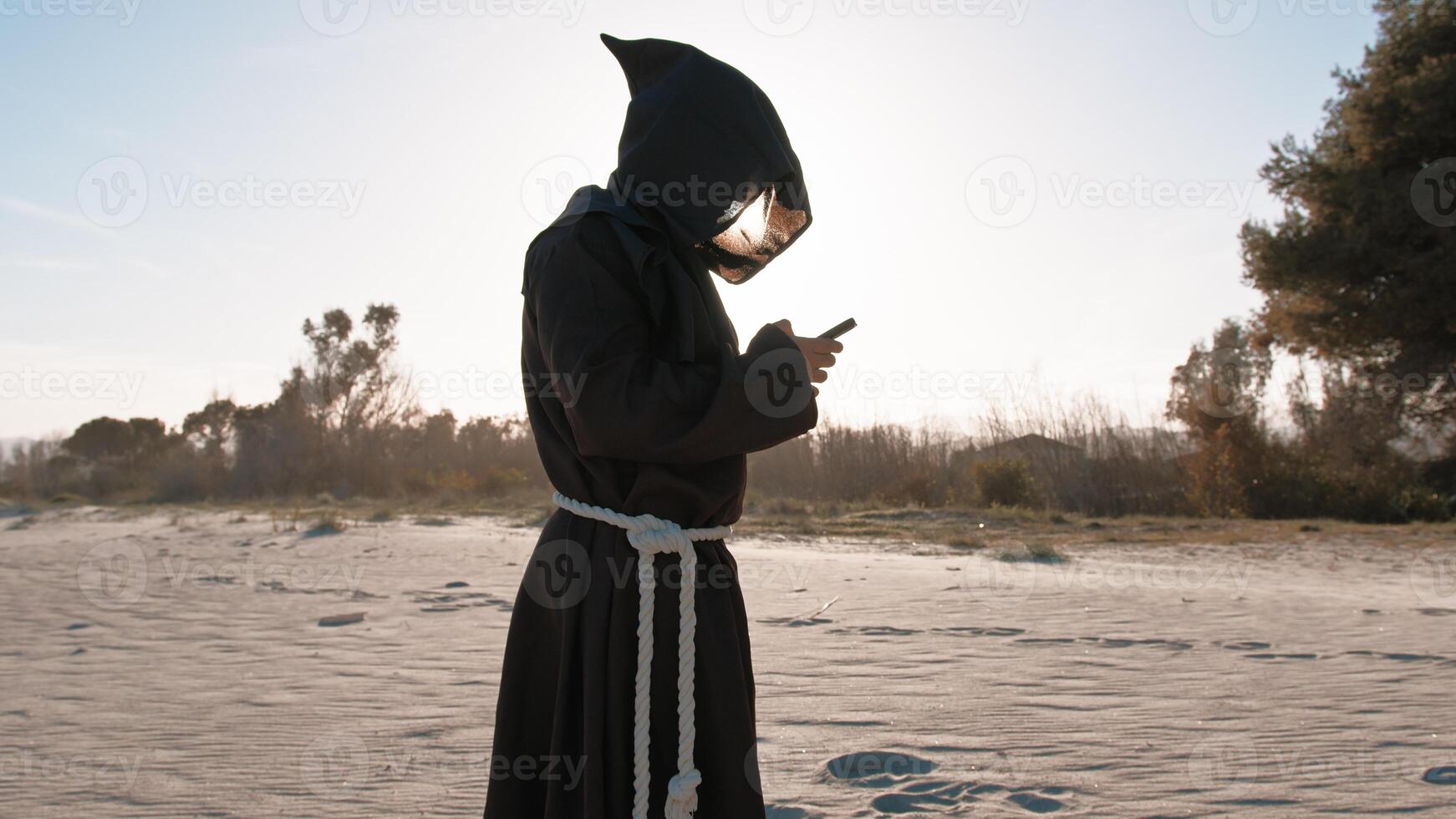 Priest Using The Smartphone At The Beach photo