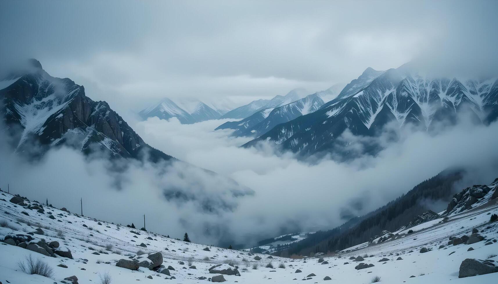 Snowy Mountain Range Covered in Mist and Clouds Aerial View photo