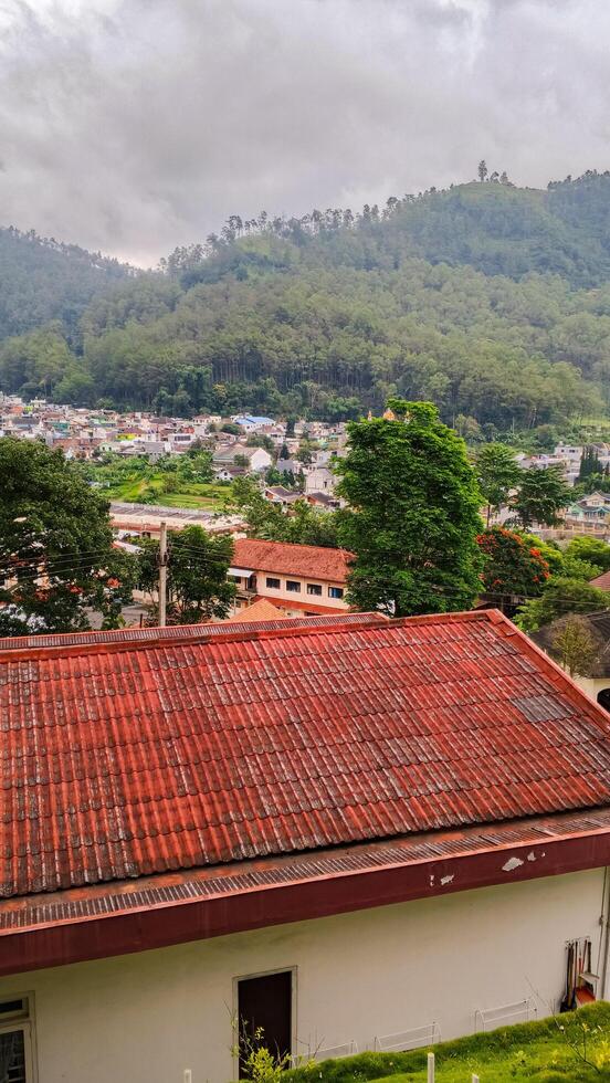 Mountain Village with Red Roofs Under Cloudy Sky Vertical Photo