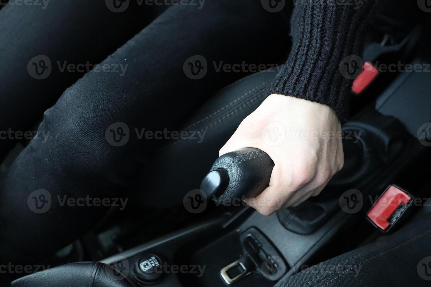 Engaging the handbrake inside a vehicles interior, showcasing dynamic interaction and safety photo