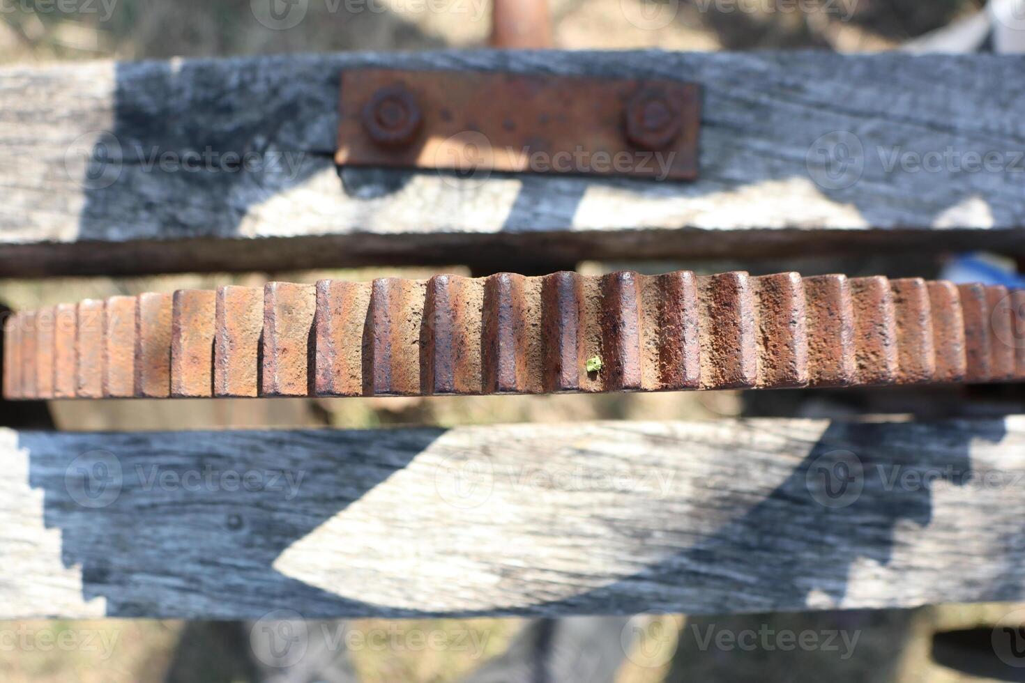 A Rusty Gear on a Wooden Structure, showcasing a blend of art and industrial decay photo