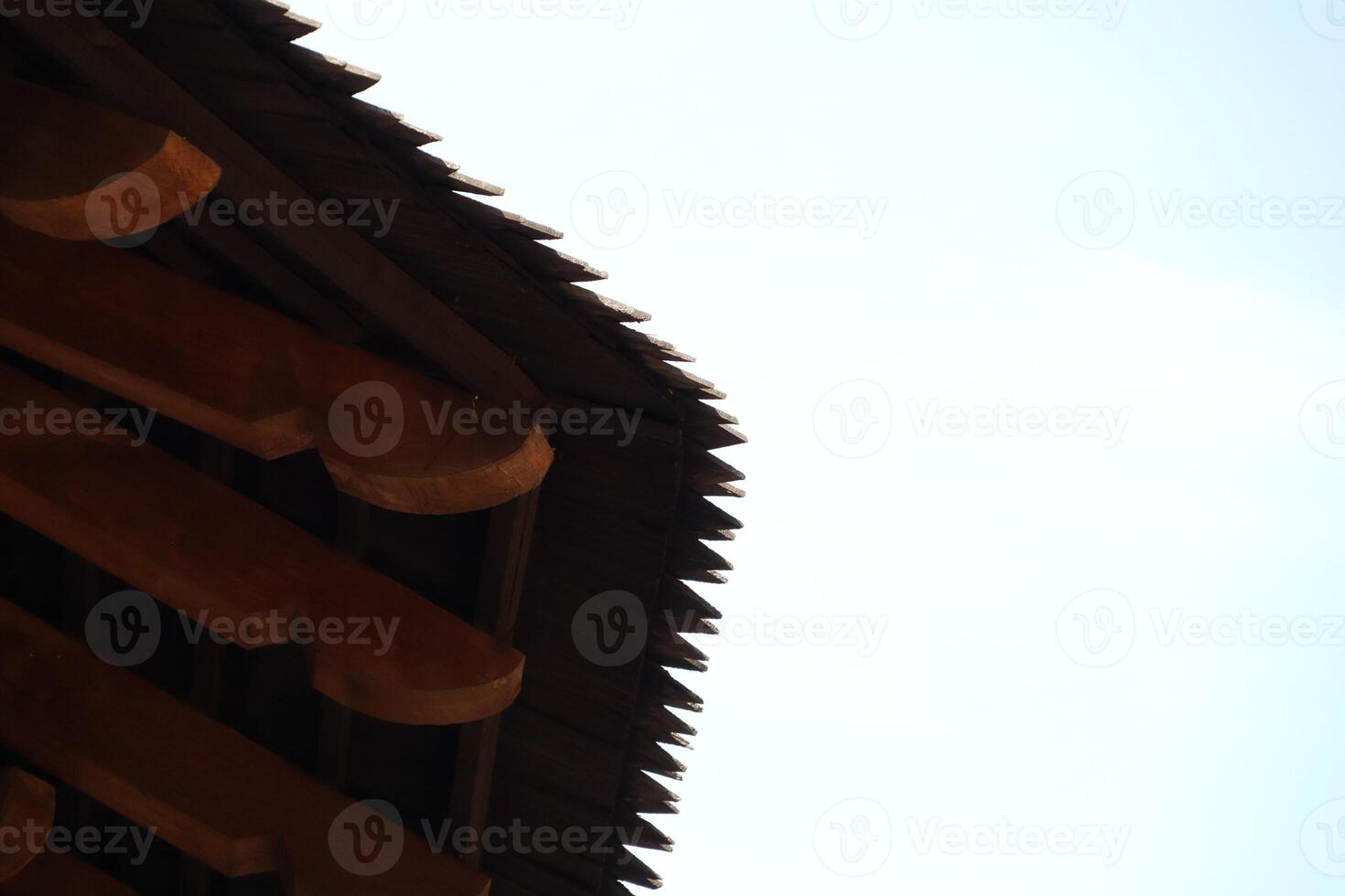 The beauty of traditional architecture is showcased with an elegant roof against the clear sky photo