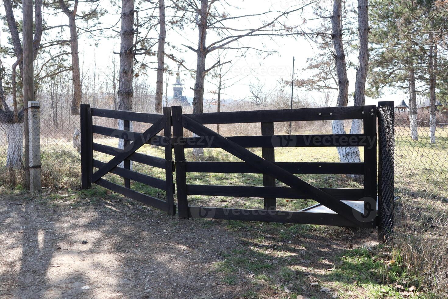A Beautifully Designed Elegant Black Wooden Gate Surrounded by Lush Nature and Landscape photo