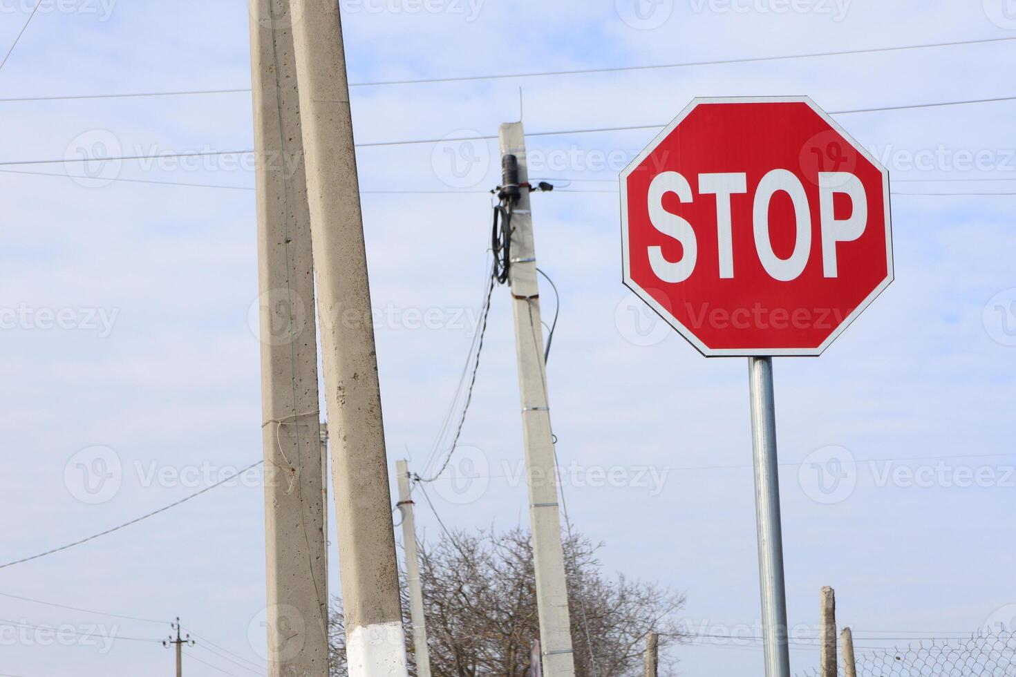A Stop Sign positioned near a Utility Pole within a serene Rural Area surrounded by nature photo