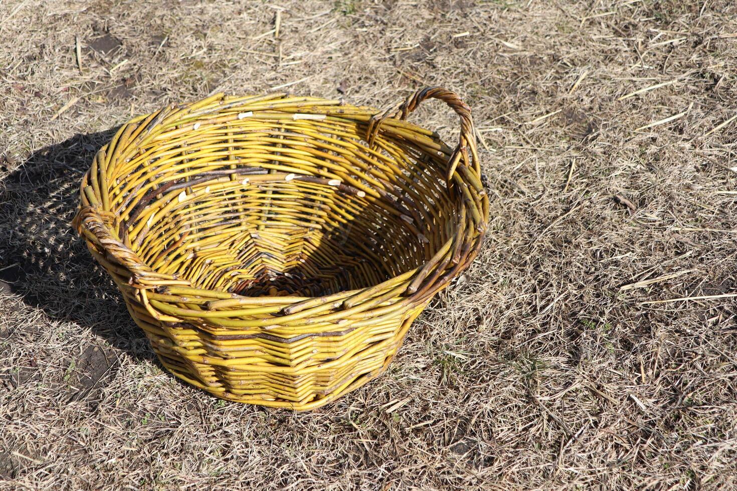 A Beautiful Rustic Woven Basket Sitting Poised on the Dry Ground of the Natural Landscape photo