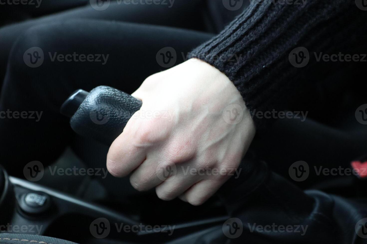 Hand Engaging the Handbrake Within the Vehicles Interior Space for Improved Control photo