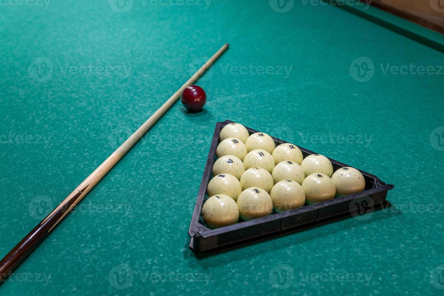 A pool table with balls and a stick photo