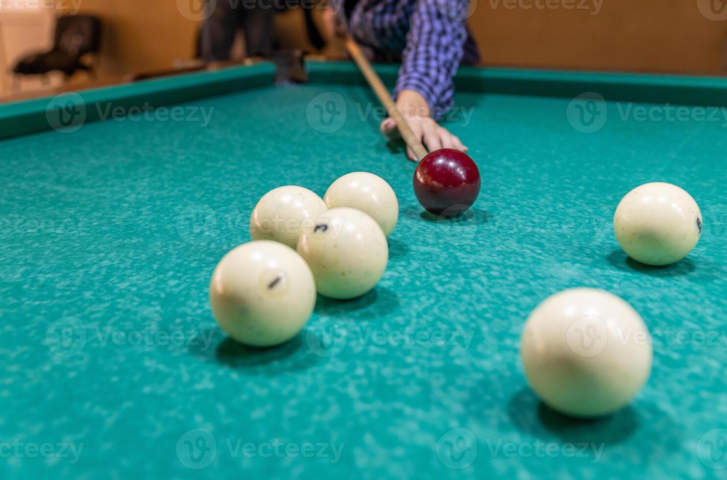 A man is playing pool with balls on the table photo