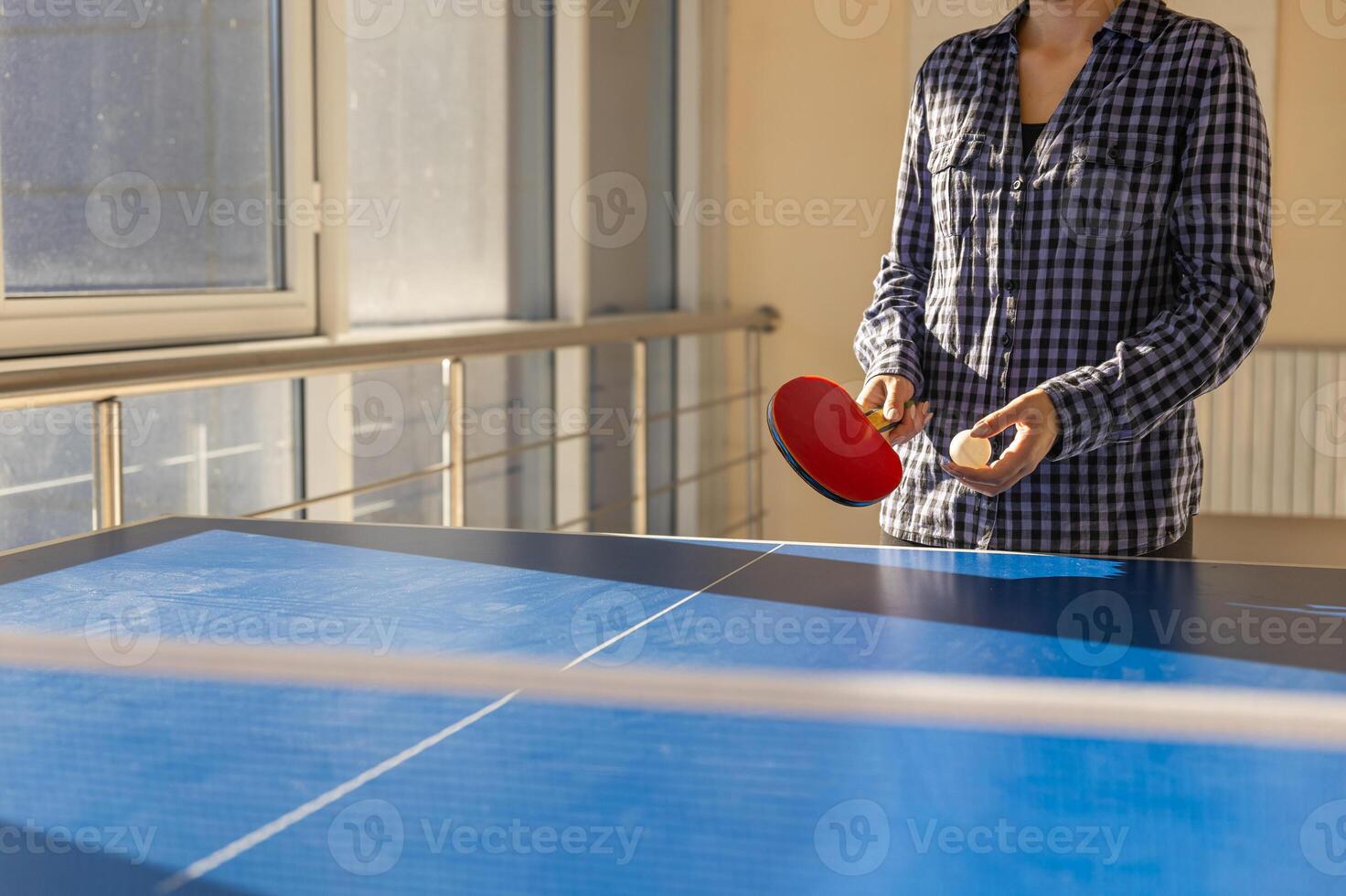 A woman is playing ping pong on a table photo