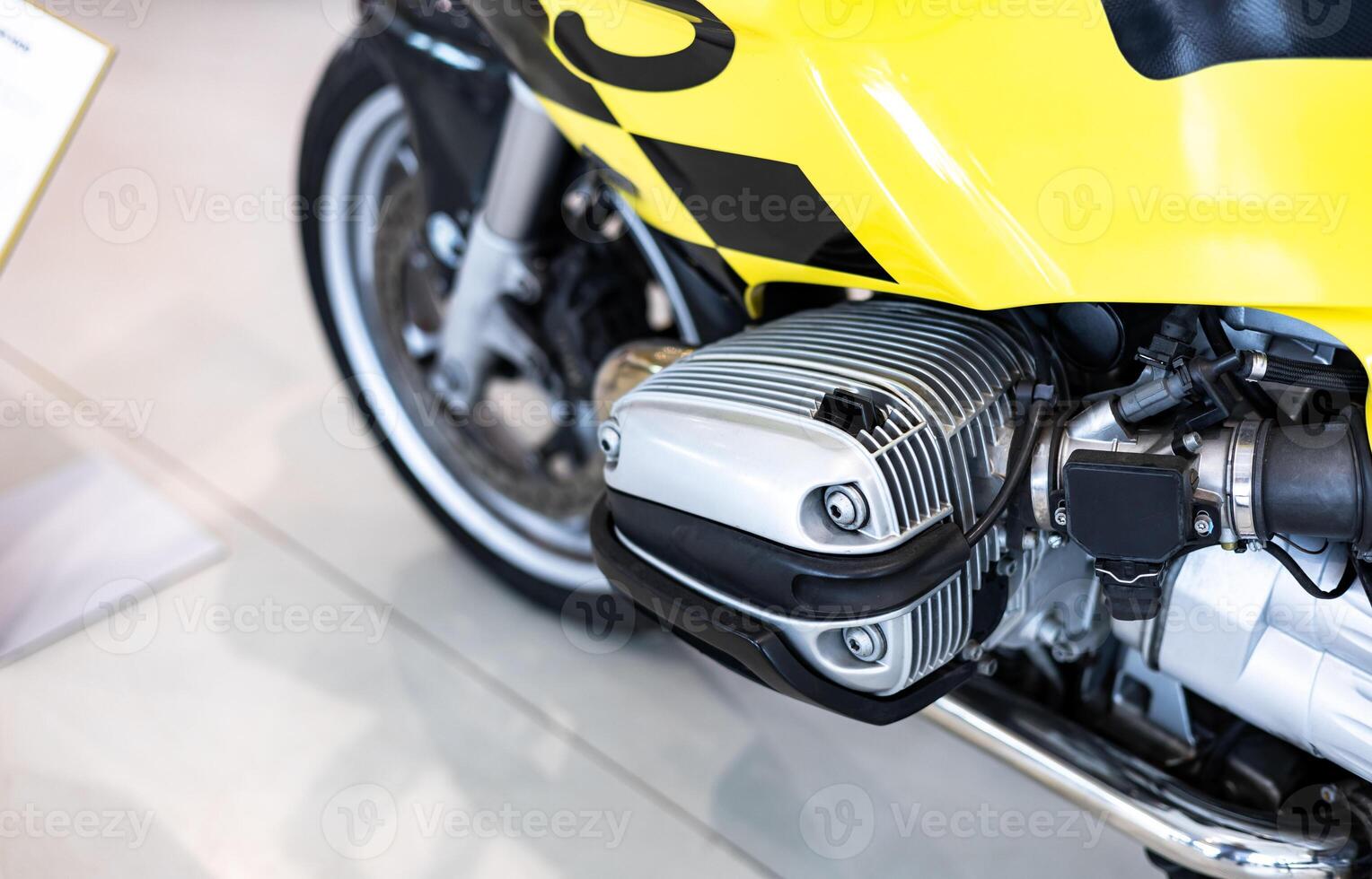 A close up of a yellow motorcycle with a black and yellow checkered flag photo