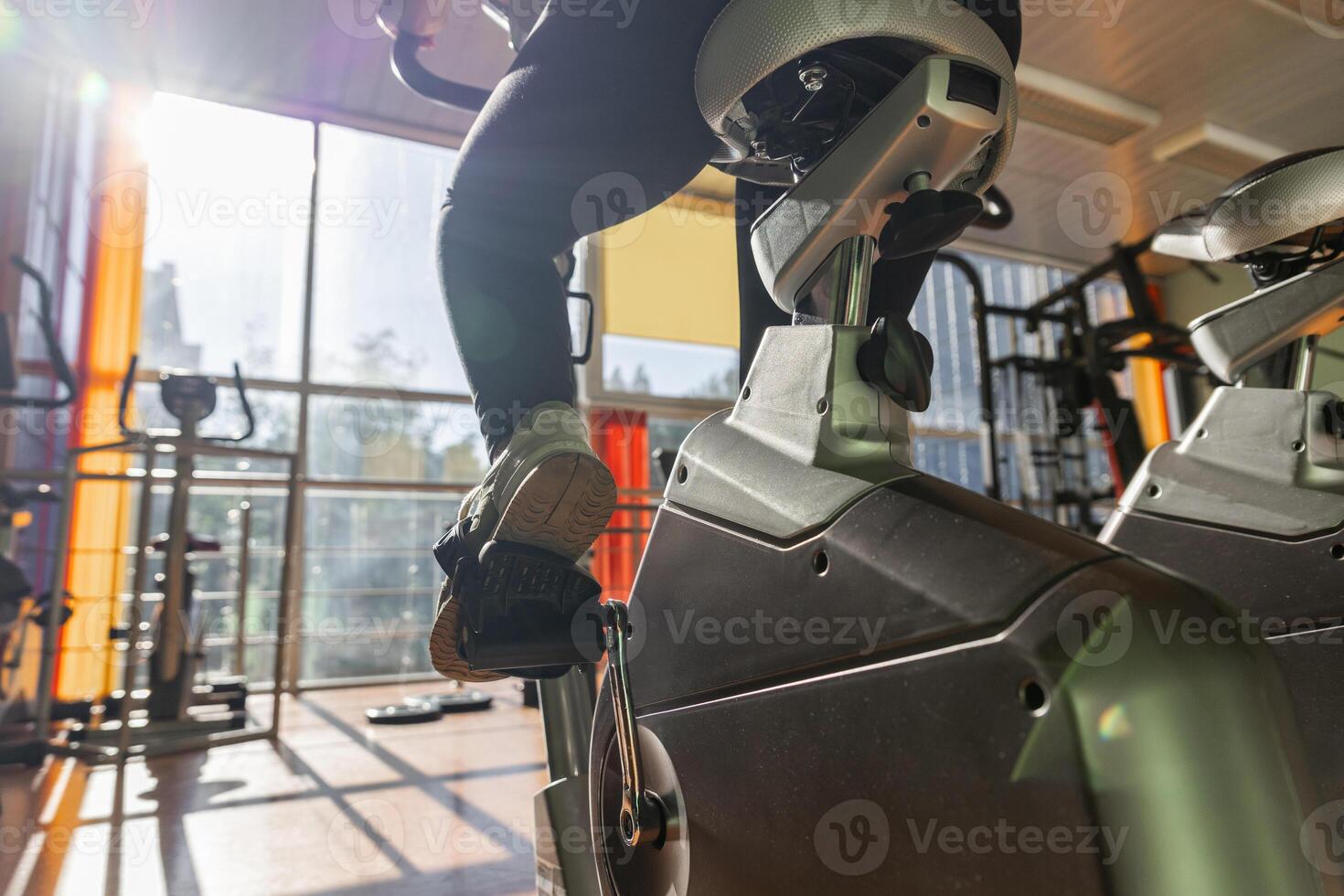 A person riding an exercise bike in a gym photo