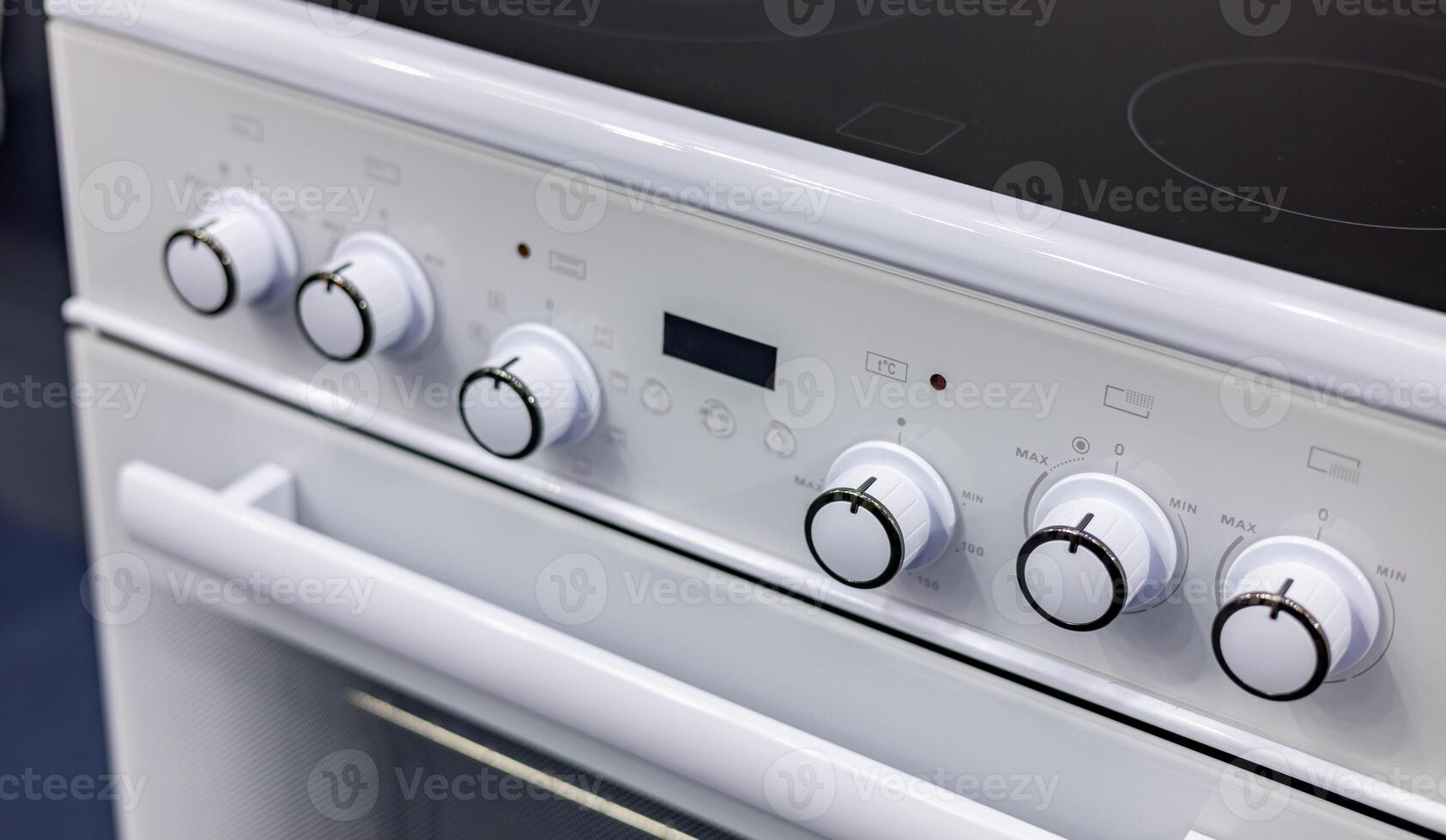 A close up of a white stove with knobs and buttons photo