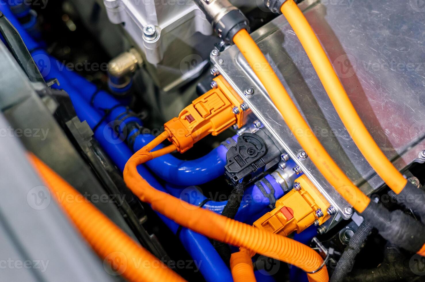 An orange and blue electrical cord is connected to a car photo