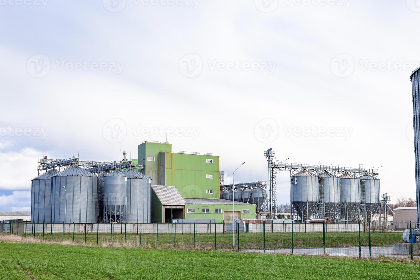 A large grain silo and a green building photo