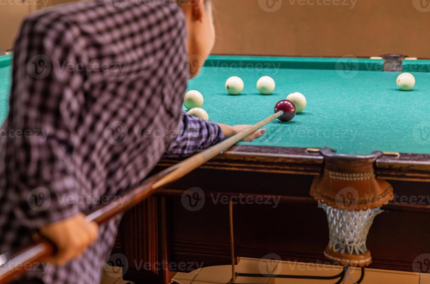 A person playing pool with a ball on the table photo