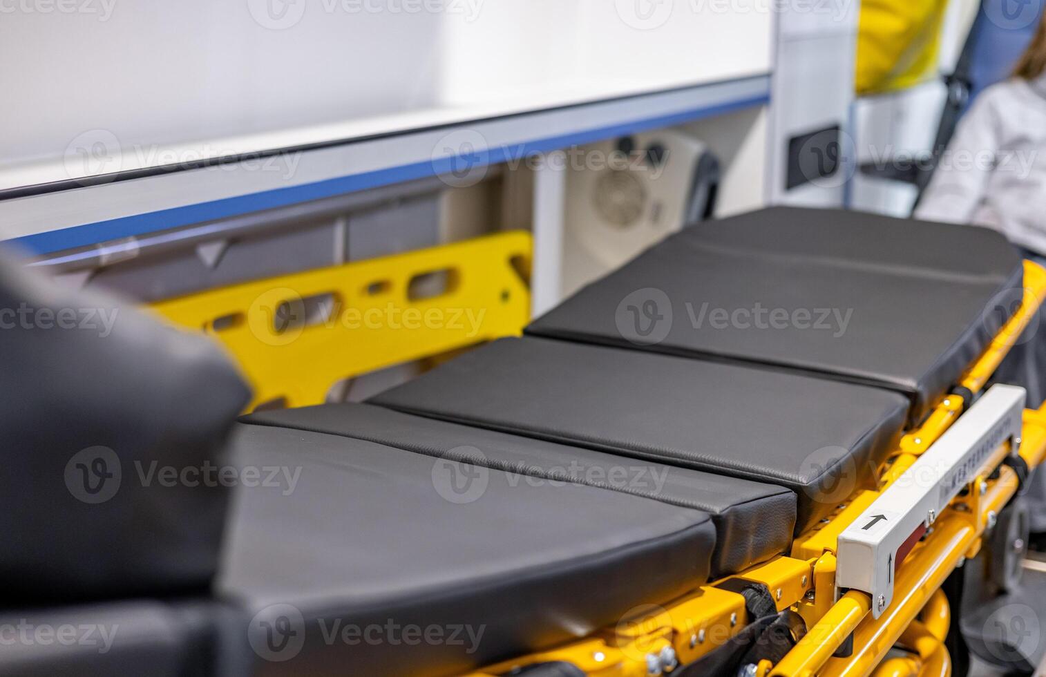 A woman is standing next to a medical stretcher photo