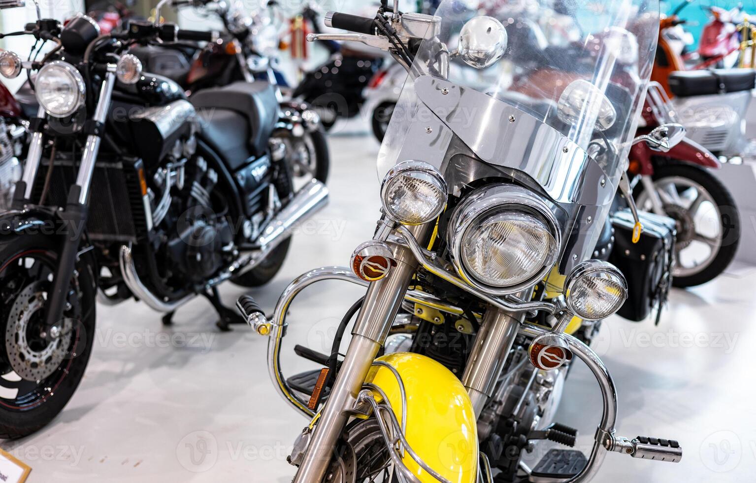 A yellow motorcycle is parked in a showroom photo