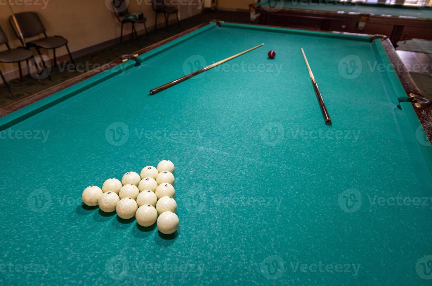 A pool table with balls and sticks photo