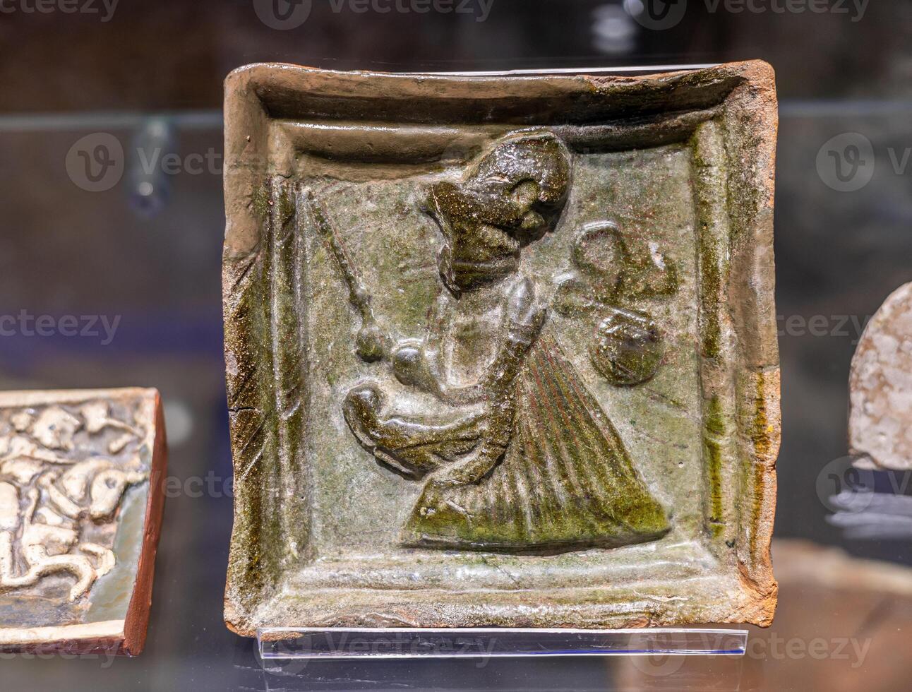 A small piece of pottery with a woman on it photo