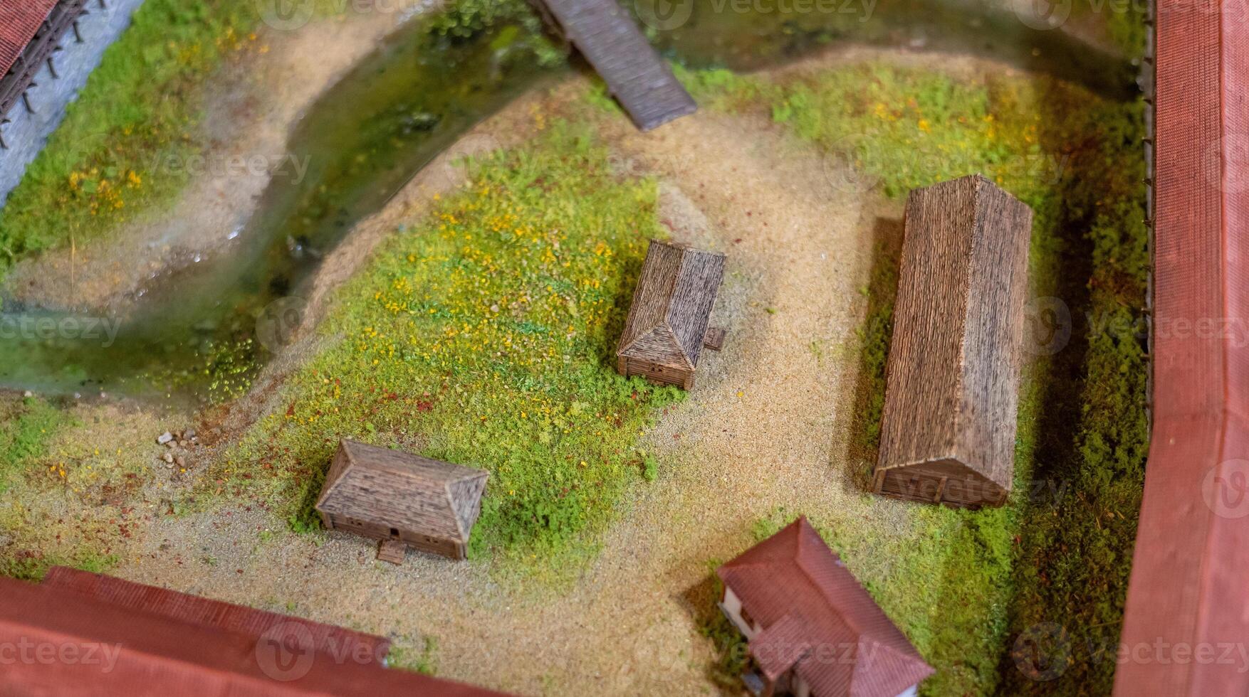 A model of a farm with a small river and a small house photo
