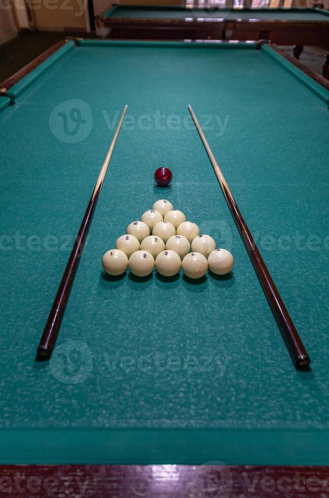 Billiards and cues on a pool table photo