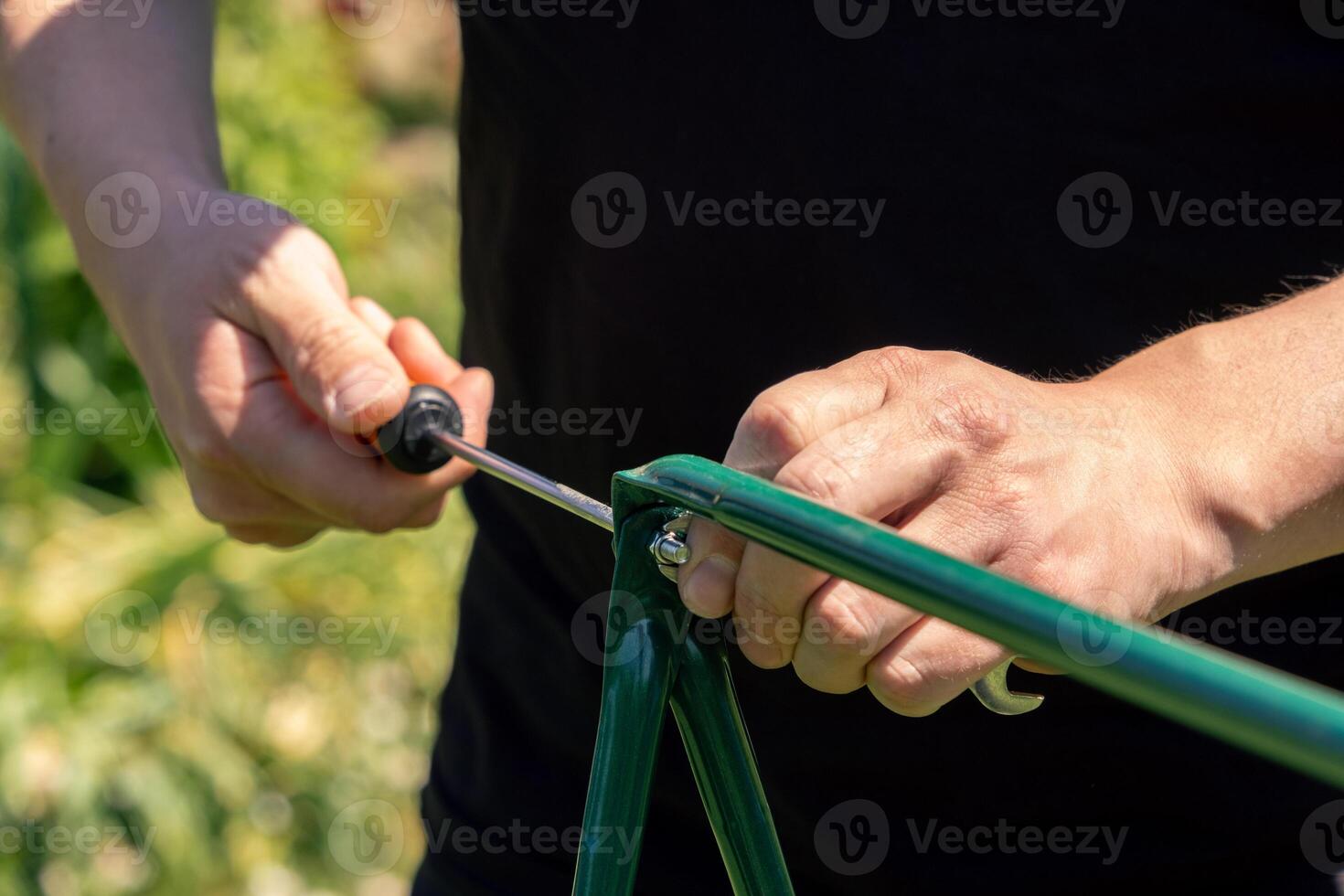 A person is using a tool to cut a piece of green wood photo