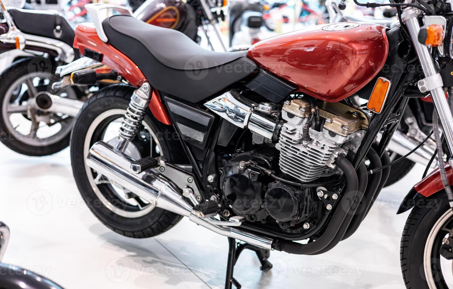 A red motorcycle is parked in a showroom photo