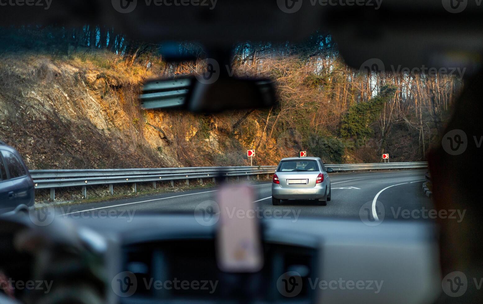 A car driving down the road with a person in the passenger seat photo